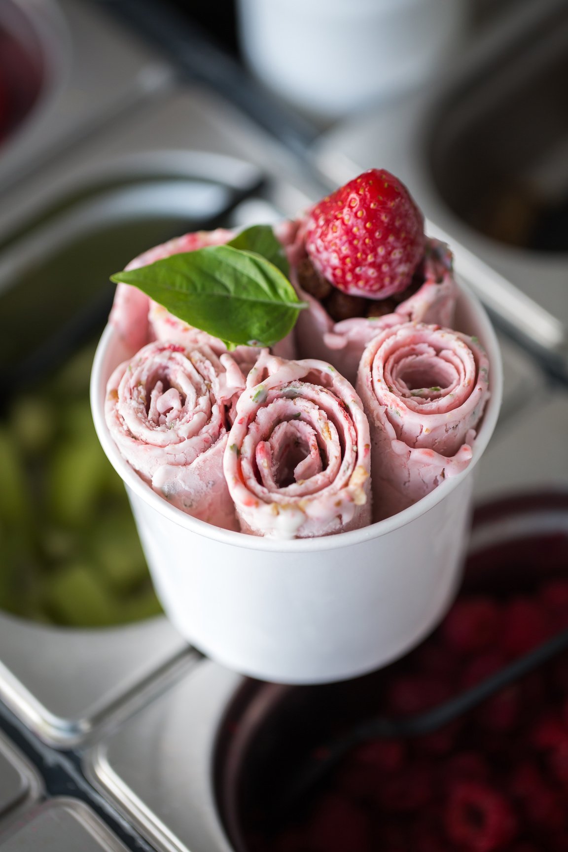 Stir-fried ice cream rolls at freeze pan. Rolled ice cream, hand made ice cream dessert. Fried ice cream machine with steel chilled pan.